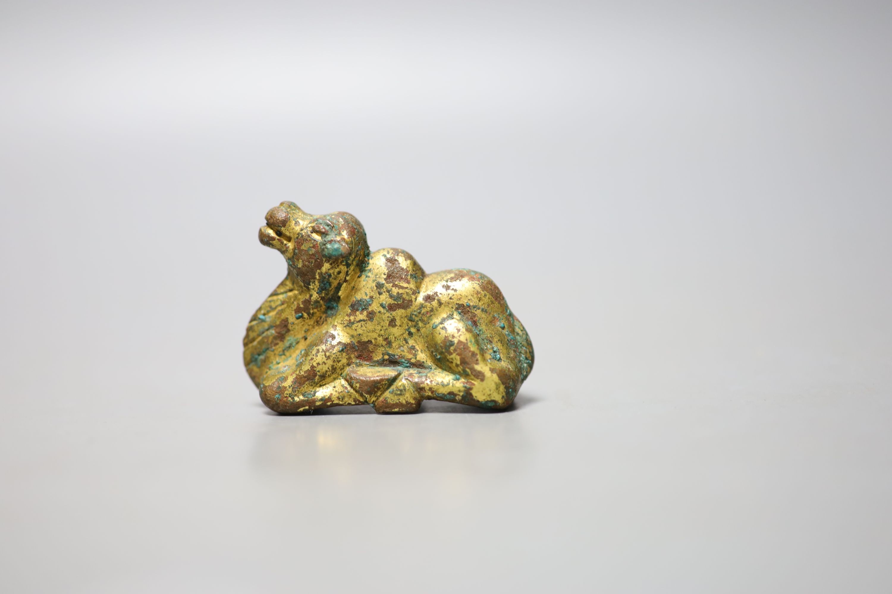 A Chinese gilt bronze figure of a kneeling camel, Han or later